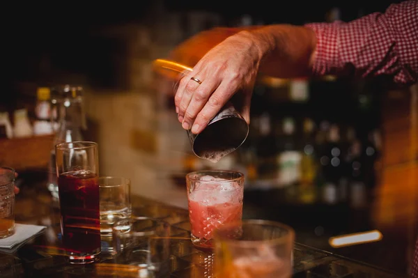 El camarero está haciendo cócteles en el mostrador del bar. — Foto de Stock