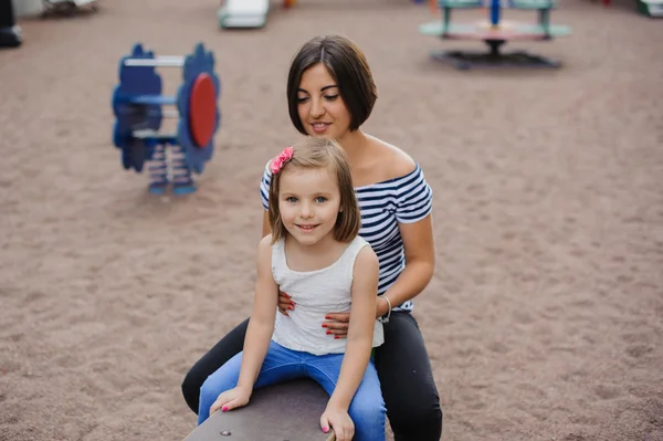 Beautiful , cheerful mother and daughter on swing — Stock Photo, Image