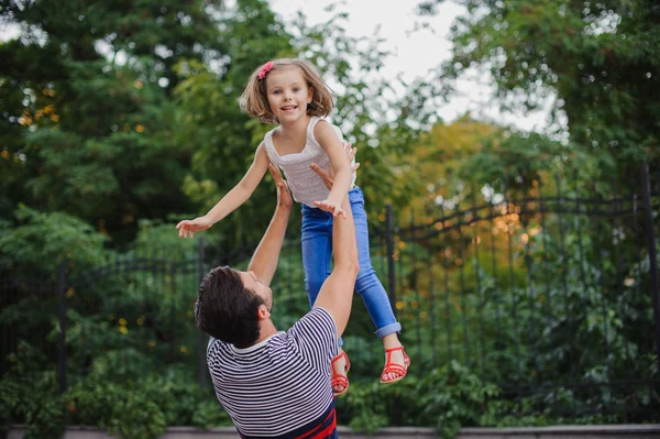 Father having fun and throwing up his daughter in park — Stock Photo, Image