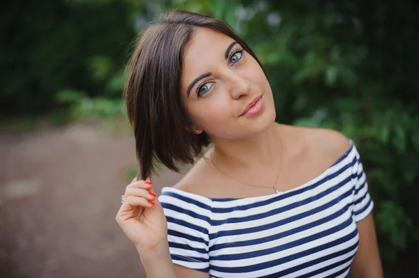 Closeup portrait of a bobbed haired young woman in park — Stock Photo, Image