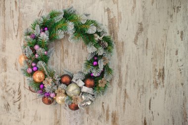 Ahşap arka plan üzerinde süslemeleri ile yeşil Noel çelenk