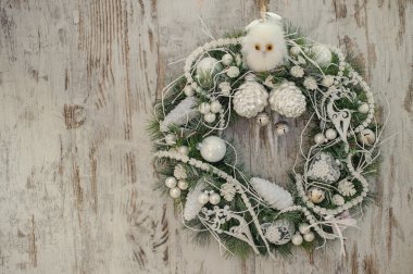 Eski ahşap arka plan üzerinde beyaz dekor ile Noel çelenk.