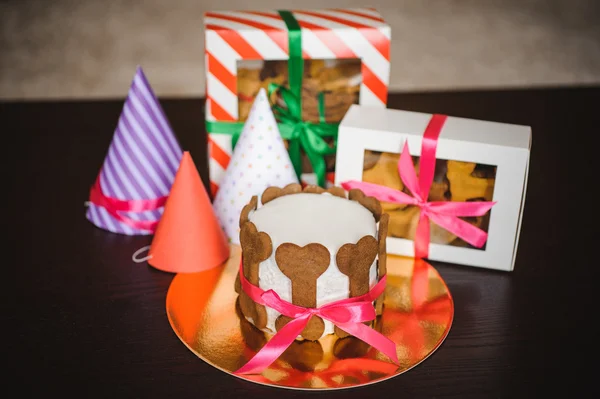 Pastel de perro y galletas en cajas con sombrero de cumpleaños — Foto de Stock