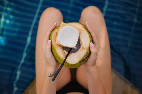 Donna che tiene la noce di cocco in piscina — Foto Stock