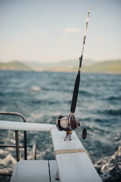 Reel fishing rod in chrome holder on boat — Stock Photo, Image