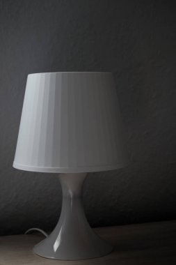 Yan taraftaki komodinin üzerinde beyaz bir komodinin dikey görüntüsü. Karanlık fotoğrafçılık