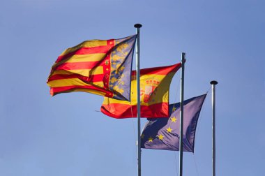 Valensiyalı topluluğun bayrakları, İspanya Krallığı ve Avrupa Birliği rüzgarda dalgalanıyor.