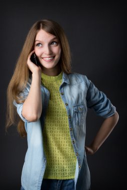 Genç ve güzel bir kız telefonda konuşuyor.