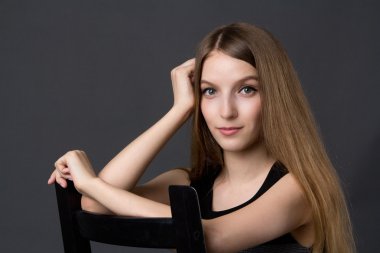 bir sandalyede oturan genç güzel kız