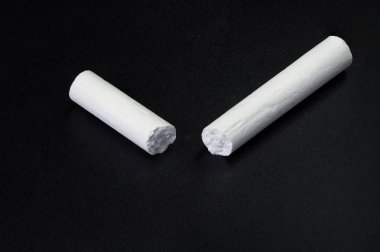 Siyah tebeşir tahtasında notlar için kırık beyaz tebeşir.