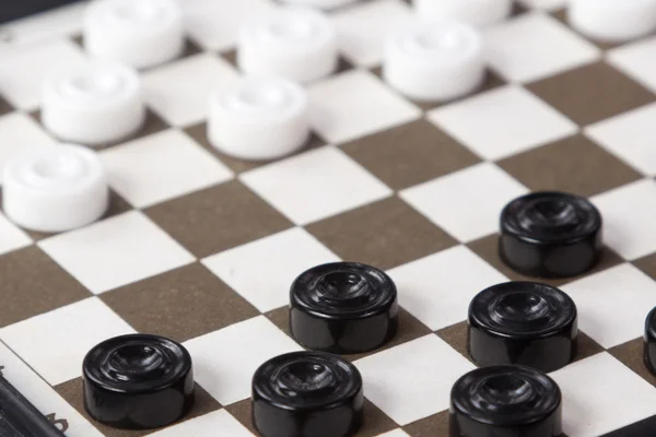 White and black checkers on the Board — Stock Photo, Image