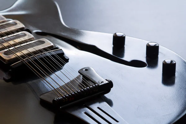 Svart gitarr liggande på bordet — Stockfoto