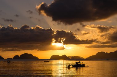 Fishmen bir tekne de akşam sunset yakınında. Filipinler