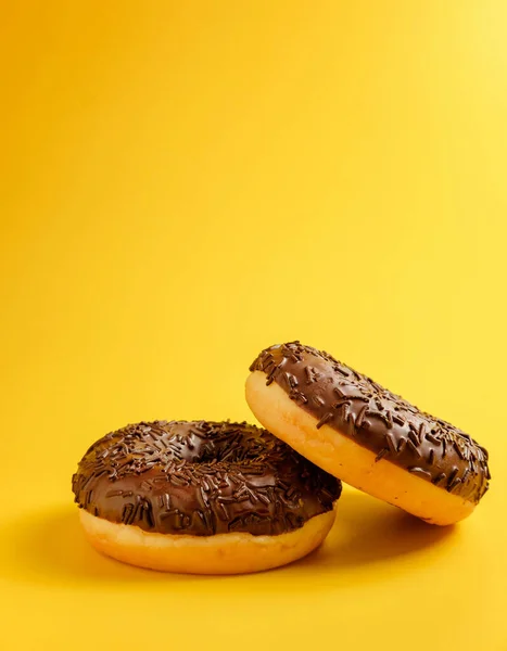 Twee Chocolade Donuts Gele Achtergrond — Stockfoto