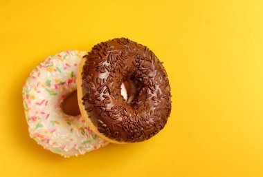 Sarı arka planda iki siyah beyaz çörek.