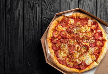 Siyah tahta üzerinde pepperoni pizza, üst görüş, yazı için yer, geleneksel İtalyan pizzası.