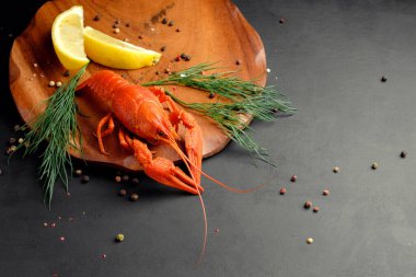 Limonlu ıstakoz ve siyah arka planda kuru biber.