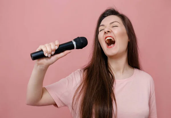 Joven Mujer Expresiva Con Micrófono Mano Sobre Fondo Rosa —  Fotos de Stock