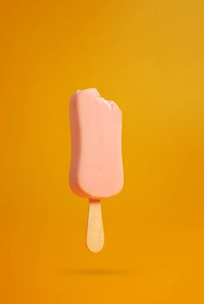 Gelado Rosa Picolé Fundo Amarelo Mordido Fora Uma Peça Pendurada — Fotografia de Stock