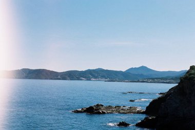 Dağlar arasında mavi bir denizin analojik görüntüsü