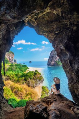 Woman sitting in the cave at Railay, Krabi, Thailand. clipart