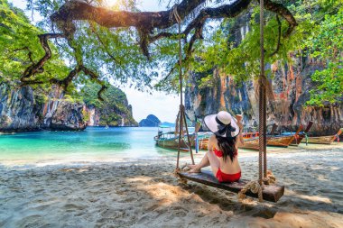 Bikinili kadın Ko Lao iniş adasında salıncakta dinleniyor, Krabi, Tayland.