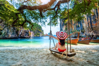 Bikinili kadın Ko Lao iniş adasında salıncakta dinleniyor, Krabi, Tayland.