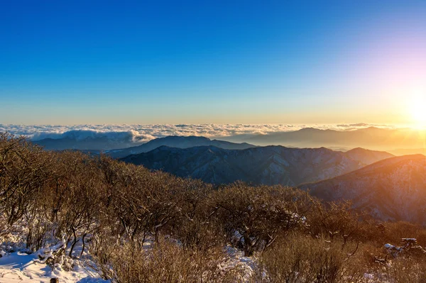 Salida del sol con hermosa llamarada de lente en las montañas Deogyusan en invierno — Foto de Stock