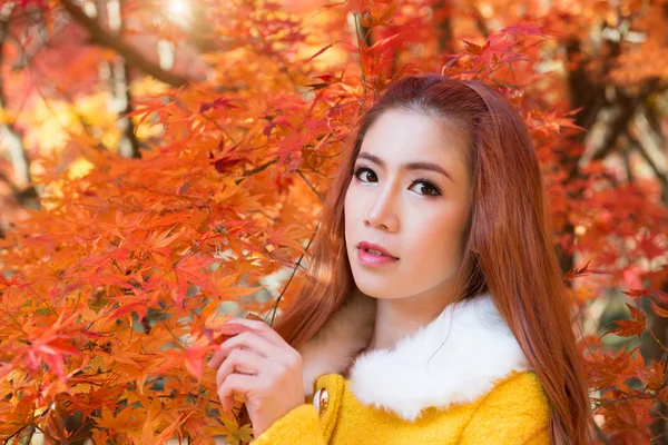 Junge Frau mit Herbstblättern im Ahorngarten. — Stockfoto