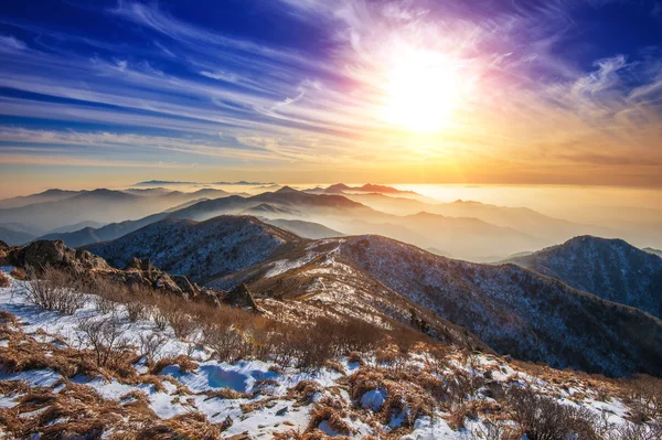 Paisaje invernal con puesta de sol y niebla en las montañas Deogyusan, S — Foto de Stock