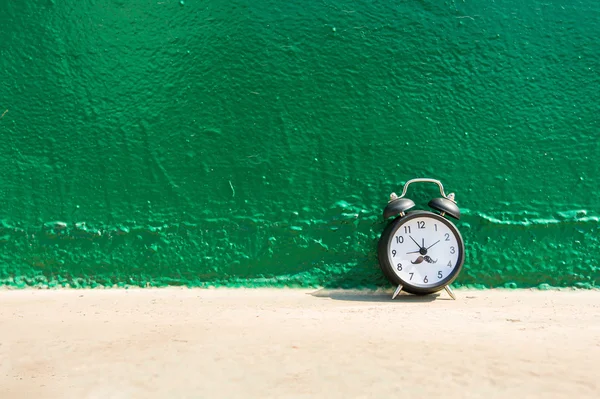 Reloj despertador sobre fondo verde . — Foto de Stock