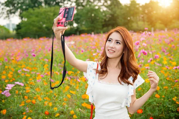 Wanita mengambil foto di bunga kosmos . — Stok Foto