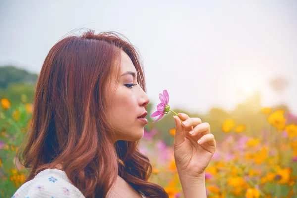 Wanita cantik muda mencium bau bunga . — Stok Foto