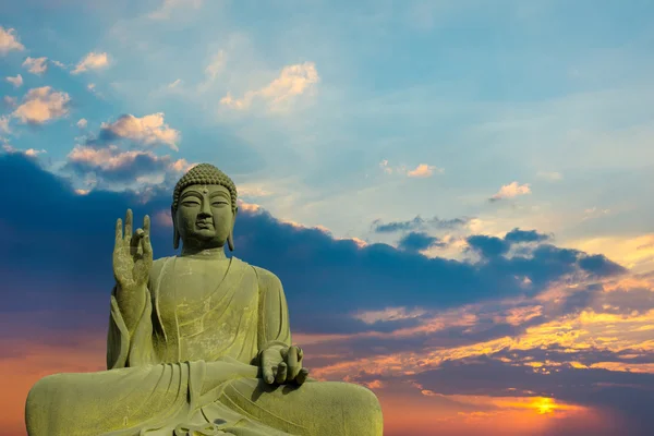 Standbeeld van Boeddha in vrede met zonsondergang achtergrond. — Stockfoto