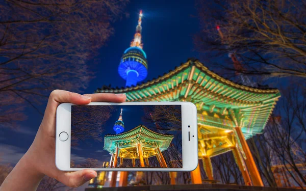 밤에 서울 타워에서의 스마트폰 걸릴 사진을 들고 손. — 스톡 사진