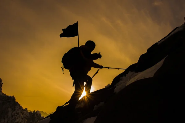 Silhouette di alpinista e tramonto . — Foto Stock