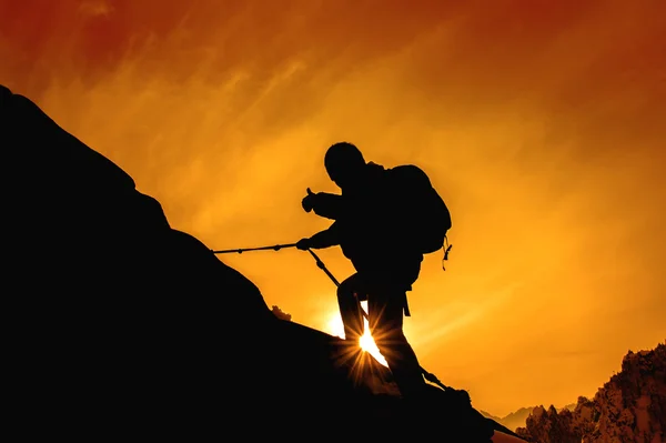 Silhouette of mountaineer and sunset. — Stock Photo, Image