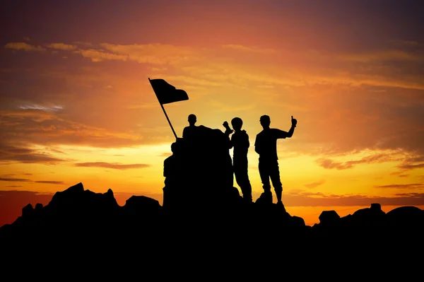 Silhouette eines Champions auf einem Berggipfel bei Sonnenuntergang. — Stockfoto