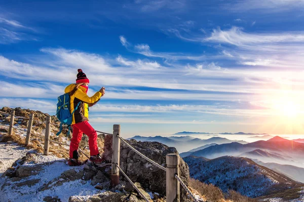 年轻女子的徒步旅行者拍照与山山顶上的智能手机 — 图库照片