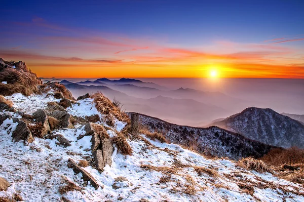 Paisaje invernal con puesta de sol y niebla en las montañas de Deogyusan, Corea del Sur . — Foto de Stock