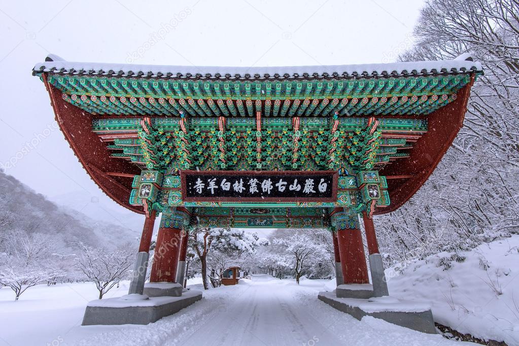 Gate of Baekyangsa Temple and falling snow, Naejangsan Mountain in winter with snow,Famous mountain in Korea.Winter landscape.