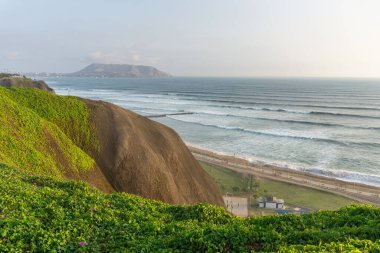 Miraflores Bölgesi Peru 'dan okyanus manzarası, bir uçurum, ağaç ve yeşil otlar.