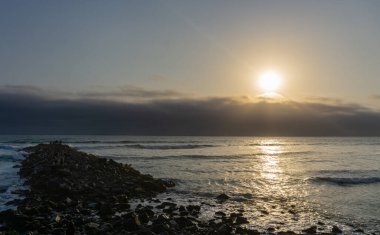 Lima Peru sahilinde gün batımı manzarası, kaya yığını.