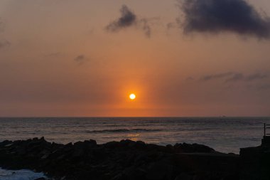Lima Peru sahilinde gün batımı manzarası, kaya yığını.