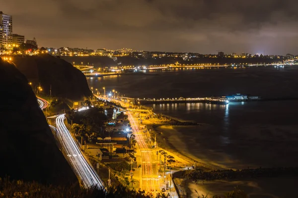 海の隣の高速道路での車の夜景黄色のライト — ストック写真