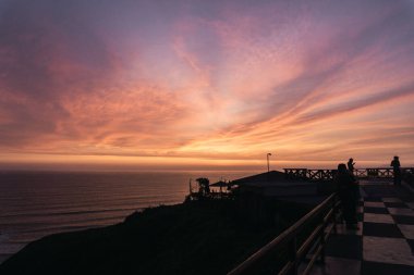 Lima Peru 'da güzel bir gün batımı, sahilin arka ışıkları, macenta gökyüzü, altın saat.,