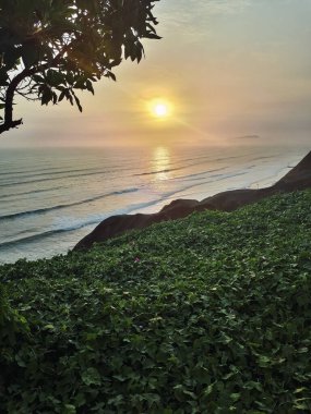 Miraflores Bölgesi, Lima Peru sahilinde güzel bir gün batımı manzarası. Yeşil çimen önplanı