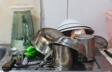 Lavabodaki eski mutfak aletleri, alüminyum kaseler, kaşıklar, çatal, bıçak, blender bardağı, bardak.