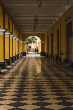 Lima Peru 'nun tarihi merkezinde Santa Rosa geçidinde sarı sütunlu siyah beyaz fayanslı patika.