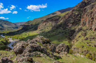 Dağlarla, ormanlarla ve önünde bir yol olan bir manzara. Güzel manzara.